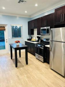 eine Küche mit einem Kühlschrank aus Edelstahl und einem Tisch in der Unterkunft Ruby’s Place in Nassau