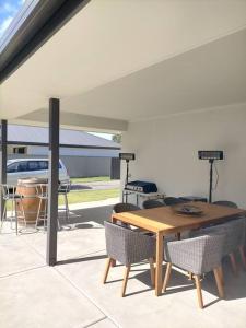 Un patio con mesa y sillas y parrilla. en Stay and Play Golf, en Worrolong