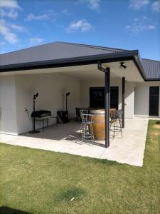 un patio con techo negro, mesa y sillas en Stay and Play Golf, en Worrolong