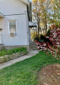 a house with a window and some flowers in the yard at Cozy 2nd Floor Apartment With Private Entrance in Chicopee