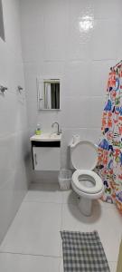 een witte badkamer met een toilet en een wastafel bij Suítes João e Maria in Ubatuba