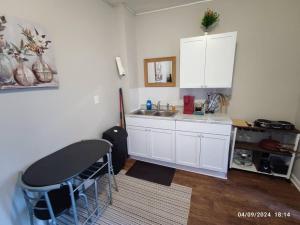 a kitchen with white cabinets and a sink and a table at Zen Haven 5- Close to Downtown Indy- Queen Bed in Indianapolis