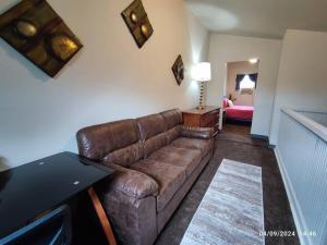 a living room with a brown couch and a table at Zen Haven 5- Close to Downtown Indy- Queen Bed in Indianapolis