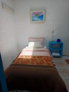 a small bedroom with a bed and a blue table at Casa-Arbol in Bogotá