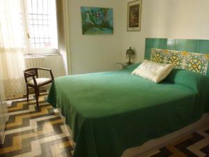 Un dormitorio con una cama verde y una silla en OS Garden - Maison de Charme, en Salerno
