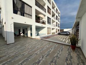 a building with a car parked in a parking lot at DEPARTAMENTO 5to piso CON VISTA AL MAR in Playas