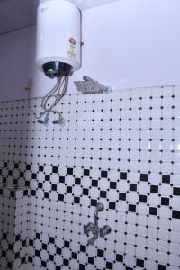 baño con lavabo y una luz en la pared en Hotel Adarsh Residency Mangalam Group, en Haridwar