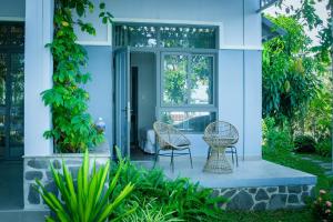 two chairs and a table on the front porch of a house at MyGarden Villa Binh Chau Hotspring in Binh Chau