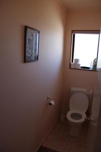 een badkamer met een toilet en een raam bij The Barn Cabins & Camp in Marahau