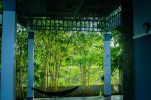 a room with a hammock in front of trees at MyGarden Villa Binh Chau Hotspring in Binh Chau