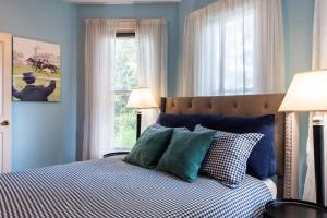 a bedroom with a bed with blue walls and a window at Spacious Historic House Near Louisville Sites in Louisville