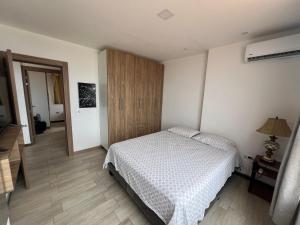 a bedroom with a bed and a wooden cabinet at CONDOMINIO MIRAMAR VISTA AL MAR Playas villamil in Playas +26 photos