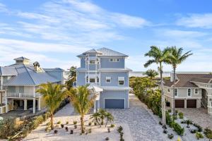 a house on the beach with palm trees at Papa's Boat House - 8214 Estero Blvd home in Fort Myers Beach