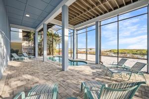 邁爾斯堡海灘的住宿－Papa's Boat House - 8214 Estero Blvd home，一个带椅子和游泳池的庭院以及窗户。