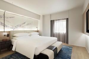 um quarto com uma grande cama branca e uma janela em Courtyard by Marriott Tokyo Ginza Hotel em Tóquio