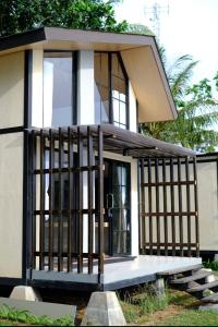 a small house with a screened in porch at Lynn Resort Carita in Sukarame