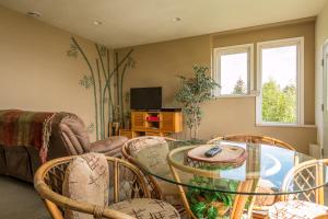 a living room with a glass table and chairs at Aloha Alaska Vacation Rentals in Homer