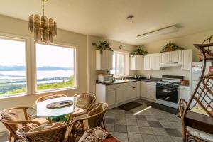 a kitchen with white cabinets and a table with chairs at Aloha Alaska Vacation Rentals in Homer