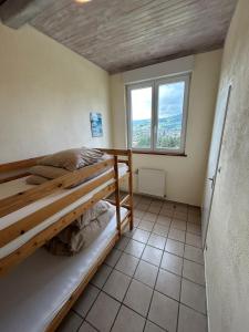een slaapkamer met een stapelbed en een raam bij Camping du Château in Granges-sur-Vologne