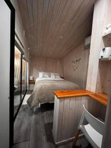 1 dormitorio con cama y techo de madera en Mini Cabaña con Tinaja en Máfil