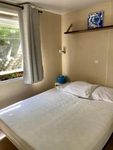 a bed in a room with a window at La Paillote de Claire in La Roque-dʼAnthéron +19 photos