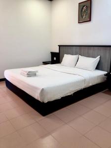 sypialnia z dużym łóżkiem z białą pościelą w obiekcie Intan Beach Resort w mieście Kuala Terengganu
