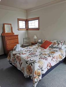 a bedroom with a large bed and a dresser at Art Deco Charm - Amazing River Views Inner City in Gisborne