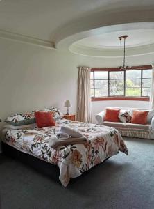 - une chambre avec un grand lit et une fenêtre dans l'établissement Art Deco Charm - Amazing River Views Inner City, à Gisborne