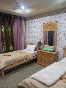 吉爾吉特的住宿－Hills n Huts Minapin Nagar，一间卧室配有两张床、镜子和梳妆台