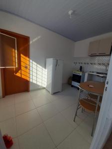 a kitchen with a table and a white refrigerator at Apt com ótima localização, com Wi-fi, próximo do Shopping e Aeroporto in Manaus