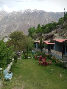 a house with a yard with tables and chairs at Hills n Huts Minapin Nagar in Gilgit