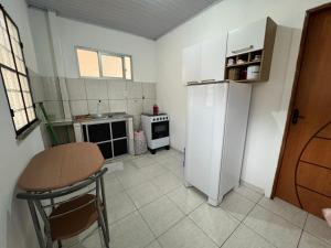 a small kitchen with a white refrigerator and a table at Apt com ótima localização, com Wi-fi, próximo do Shopping e Aeroporto in Manaus