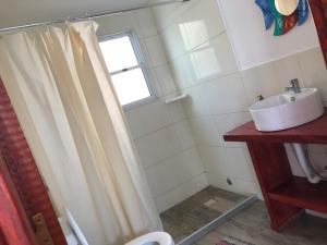a bathroom with a shower curtain and a sink at Posada Agua Marina in La Paloma