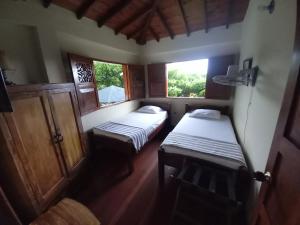 Kleines Zimmer mit 2 Betten und 2 Fenstern in der Unterkunft Alojamiento rural la pradera in Montenegro