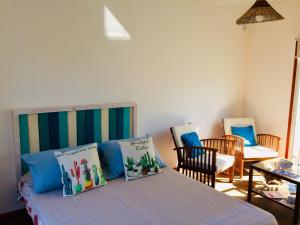 1 dormitorio con 1 cama con almohadas azules en Posada Agua Marina, en La Paloma
