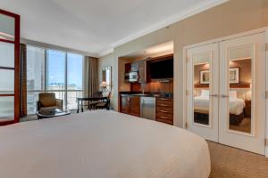 a bedroom with a large white bed and a kitchen at MGM Studio Suite with POOL VIEW Tower 1 in Las Vegas