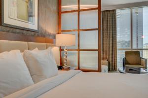 a hotel room with a bed and a chair and a window at MGM Studio Suite with POOL VIEW Tower 1 in Las Vegas