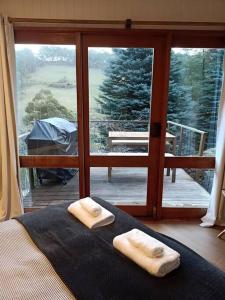 ein Schlafzimmer mit einem Bett mit zwei Handtüchern darauf in der Unterkunft Wilderness Retreat 10mins to CBD, bath tub, BBQ in Ridgeway