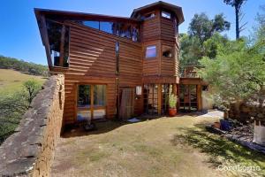 ein großes Holzhaus mit einem Zaun in der Unterkunft Wilderness Retreat 10mins to CBD, bath tub, BBQ in Ridgeway