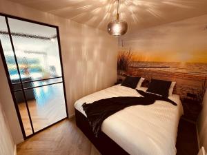 een slaapkamer met een bed met een groot raam bij Studio Duinenzicht in Koksijde