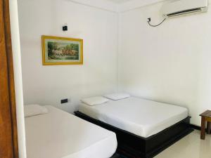 מיטה או מיטות בחדר ב-Hotel Siyathma polonnaruwa