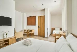 ホーチミン・シティにあるMIHN SUITES BEN THANHのベッドとダイニングルームがあるホテルの部屋