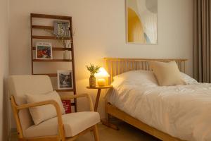 首爾的住宿－이수환상，一间卧室配有一张床、一把椅子和一盏灯