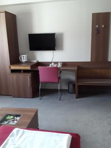 Μια τηλεόραση ή/και κέντρο ψυχαγωγίας στο Aura's west accommodation private parking in front yard
