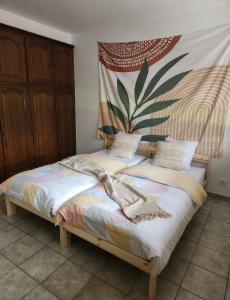 a bedroom with a bed with a painting on the wall at Villa entière au calme in Soufflenheim