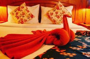 a red swan made out of towels on a bed at Sayang Beach Resort Koh Lanta in Ko Lanta