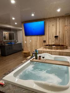 a large bath tub with a blue screen in a bathroom at Romantic Luxury Retreat with Private Sauna & Spa, Pet Friendly, Elkside Hideout B&B in Canmore