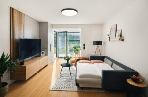 sala de estar con sofá y TV de pantalla plana en Beta Home - Free Garage, Metro, Garden en Praga