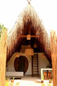 een hut met een rieten dak en stoelen bij Pretty Jungle Siargao in San Isidro