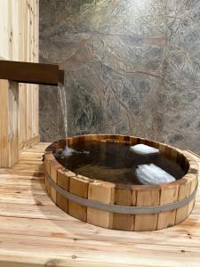 une baignoire en bois avec une fontaine dans l'établissement Luxury suite with Sauna and Spa Bath - Elkside Hideout B&B, à Canmore